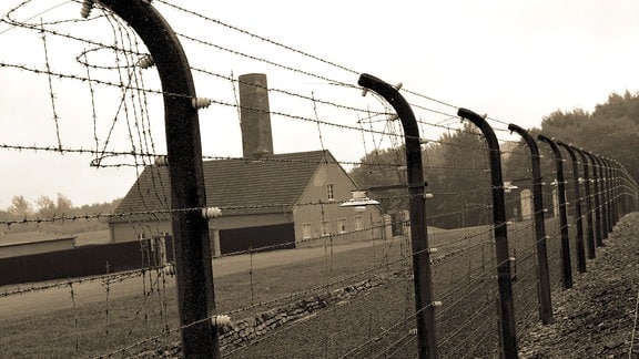 Blick durch einen Zaun auf das Krematorium des ehemaligen KZ Buchenwald