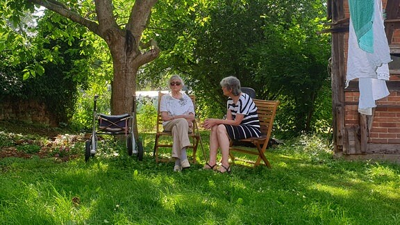 Leonore Pengelmit ihrer ihre Tochter im Garten sitzend. 