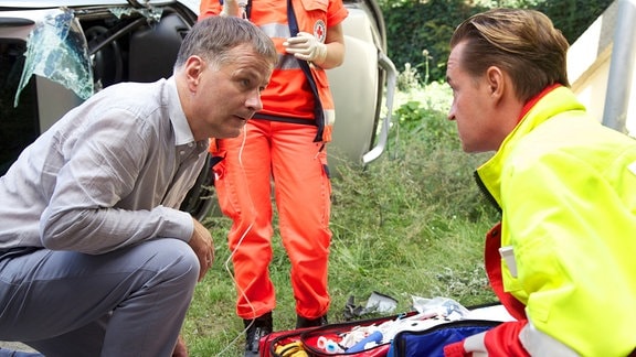 Nach dem Unfall, in den er selbst verwickelt war, leistet Dr. Heilmann (Thomas Rühmann, links) sofort Erste Hilfe.