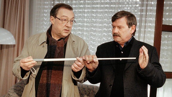 Die Kommissare Schmücke (Jaecki Schwarz, li.) und Schneider (Wolfgang Winkler) wundern sich, warum der blinde Masseur seinen Blindenstock zurückgelassen hat.