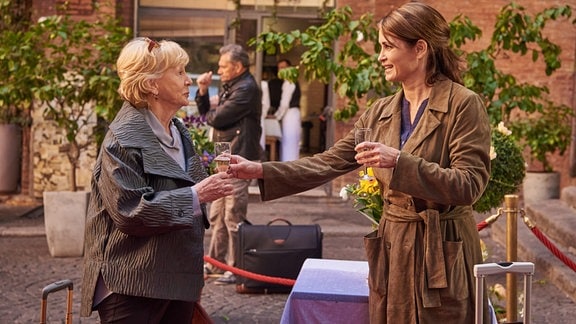 Andrea (Anja Kling, re.) reicht ihrer Mutter Helga (Christine Schorn) ein Glas Sekt.