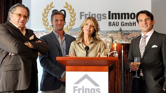 Nina (Ursula Karven) überrascht ihren Mann Robert (Hans-Werner Meyer, rechts) und den Bauunternehmer Frings (Michael Brandner, links) mit der Neuigkeit, dass sie für Philipps (Henning Baum) Ökopartei als Spitzenkandidatin antreten will.