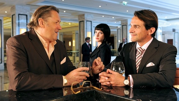 Die PR-Spezialistin Jacqueline (Jana Klinge) wacht darüber, dass Bürgermeister Robert (Hans-Werner Meyer, rechts) seine politischen Kontakte zu dem Unternehmer Frings (Michael Brandner) pflegt.