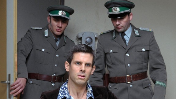 Robert Schnyder (Steffen Groth, M.) wird wegen Beihilfe zur Republikflucht inhaftiert und im Vernehmungsraum von Falk verhört.