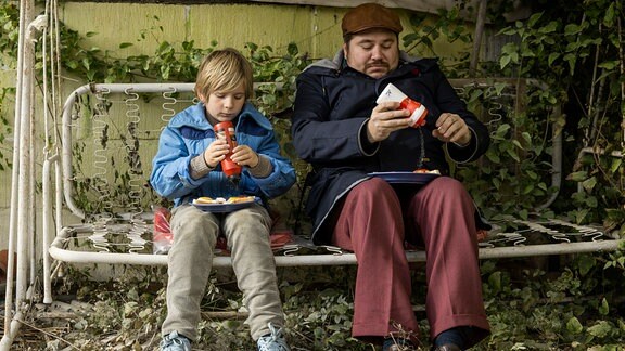 William und sein Onkel Nils essen im Garten Eier.