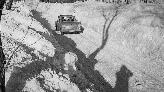 Katastrophenwinter 1978/79 auf Rügen Ein Trabant passiert eine beräumte Straße.