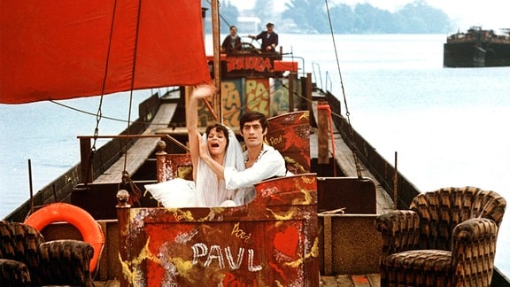Auf dem Flussschiff Paula auf der Spree: Während einer Liebesnacht gehen Paula (Angelica Domröse) und Paul (Winfried Glatzeder) auf eine imaginäre Reise zu Paulas Familie, den Flussschiffern.