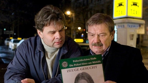 Schneider (Wolfgang Winkler, rechts) verteilt am Imbiss Phantombilder unter den Taxifahrern.