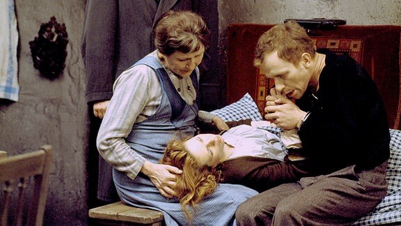 Mutter Fent (Ursula Braun) stützt den Kopf ihrer Tochter Hete (Renate Krößner), Dr. Möller (Heinz Behrens, stehend) und Hetes Verlobter Paul (Hermann Beyer) sehen bestürzt zu.