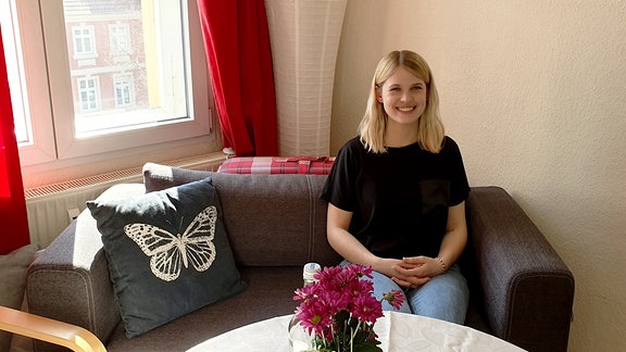 Studentin Aliena Mard auf ihrem Sofa