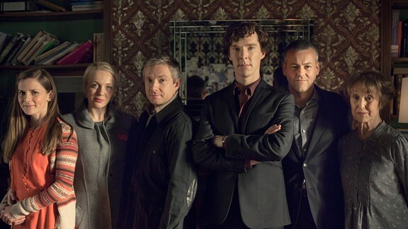 Yon links nach rechts: Molly Hooper (Louise Brealey), Mary Morstan (Amanda Abbington), John Watson (Martin Freeman), Sherlock Holmes (Benedict Cumberbatch), Detective Inspector Lestrade (Rupert Graves) und Mrs. Hudson (Una Stubbs)