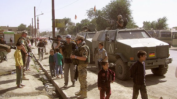 Bundeswehrsoldaten zwischen afghanischen Menschen