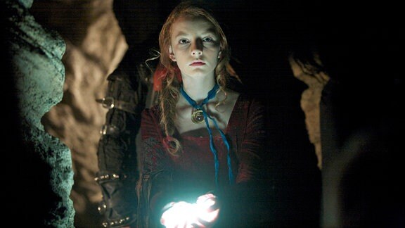 Im unterirdischen Gang leuchten die magischen Perlen Maria (Dakota Blue Richards) den Weg.