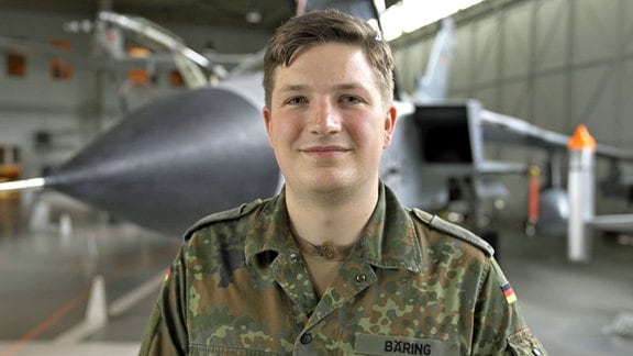 Sven Bäring von QueerBw vor einem Jagdflieger.