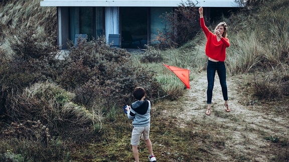 Die Anwältin Sophie Cross (Alexia Barlier) spielt mit ihrem sechsjährigen Sohn Arthur (Martin Verset) vor dem Strandhaus.