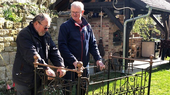 Auch die Nachbarn Matthias Eichhorn und Bernd Spindler haben sich etwas zur Verschönerung des Dorfplatzes ausgedacht. Die möbeln das uralte Bettgestell wieder auf, das bepflanzt werden soll.
