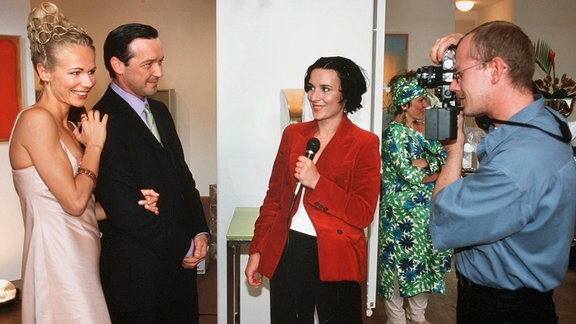 Die erfolgreiche Stilberaterin Juliane (Claudine Wilde, li.) eröffnet zusammen mit ihrem Freund, dem Galerist René (Michael Roll, 2. v. li.) eine Kunstausstellung, die von der Presse positiv aufgenommen wird.