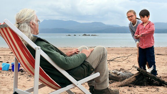 Gordie McLeod (Billy Connolly) macht mit seinen Enkelkindern Lottie (Emilia Jones) und Mickey (Bobby Smalldridge, re.) einen Ausflug an den Strand.