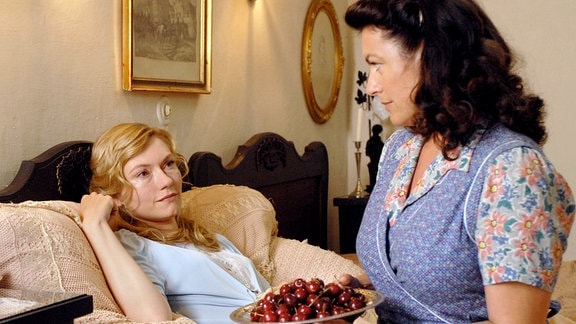 Clara (Christine Neubauer, re.) bringt Kirschen für Ariane (Johanna Christine Gehlen), der kränkelnden Frau des Gutsherren.