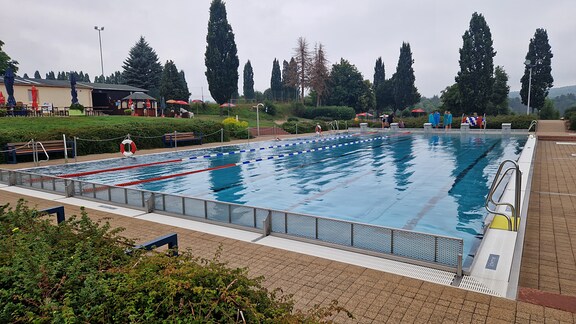 Die eigenständige Gemeinde unterhält ein schickes Freibad. Am verregneten Wochenende trainieren nur die Schwimmer eines Trainingslagers.