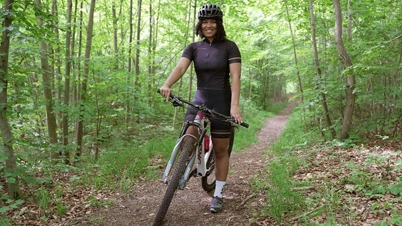 Lelia König aus Jena mit einem Fahrrad im Wald.