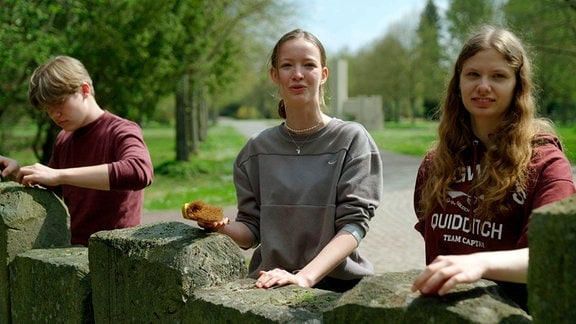 Schülerinnen und Schüler pflegen auf dem Westfriedhof Magdeburg ein Soldatengrab