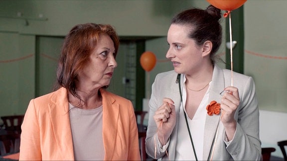 Sophie (Sophie Hutter, re.) versucht der Politikerin Silke Friedmann (Barbara Frey, li.)  zu vermitteln, wie die Partei zum Thema Wolf steht.