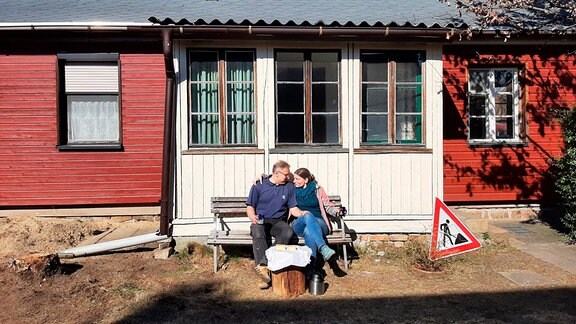 Ehepaar Sandig vor ihrem Holzhaus