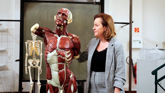 Prof. Dr. Heike Kielstein steht neben einem Modell des menschlichen Körpers.