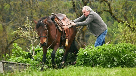 Barthl (Friedrich von Thun) versucht, das Pferd aus seinem Gemüsebeet zu bewegen.