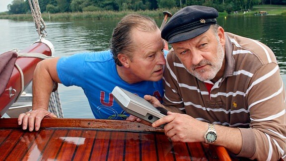 Männer und Technik: Die Hobby-Segler Klaus (Paul Faßnacht, li.) und Fred (Leonard Lansink) schlagen sich auf ihrem Boot mit einem Empfangsgerät herum.