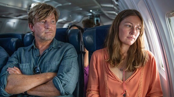 Ein Mann und eine Frau sitzen in einem Flugzeug