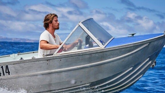 Ein Mann in einem kleinen Speedboot.