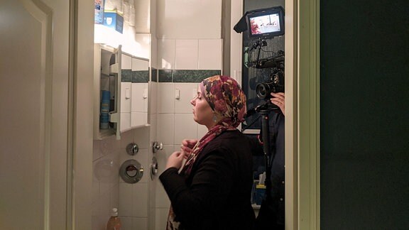 Karoline Roscher-Lagzouli legt während der Dreharbeiten ihr Kopftuch vor dem Spiegel an.