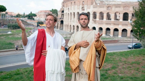 Checker Tobi (links) und Fabio, verkleidet als Senatoren, vor dem Colosseum in Rom.