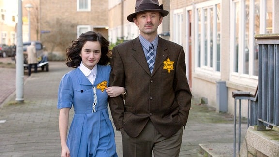 Anne (Luna Cruz Perez) und ihr Vater Otto (Noël van Santen) müssen den “Gelben Stern” tragen.