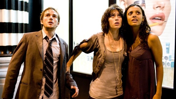 Rob (Michael Stahl-David), Marlena (Lizzy Caplan, Mitte) und Lily (Jessica Lucas) beobachten fassungslos die Zerstörungen, die eine riesige schemenhafte Gestalt um sie herum anrichtet.