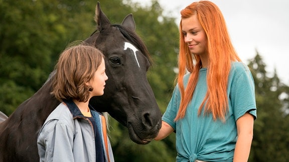 Mika (Hanna Binke) und Ari (Luna Paiano, li.) haben einen besonderen Draht zum berühmten Hengst Ostwind.