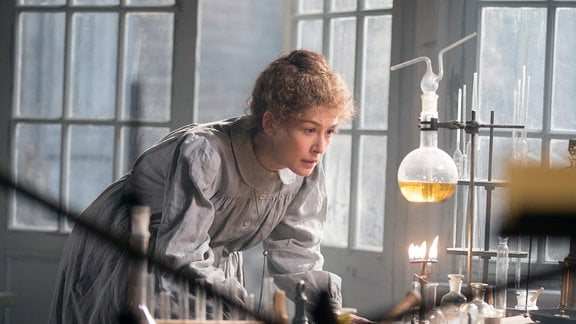 Marie Curie (Rosamund Pike) wurde die Begründerin der Radiochemie und erhielt für ihre bahnbrechenden Entdeckungen als erste Frau 1903 den Nobelpreis für Physik gemeinsam mit ihrem Mann und 1911 den Nobelpreis für Chemie.