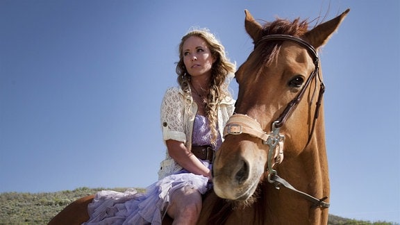  Dani ( Danielle Chuchran) darf das Pferd  „Little Annie“ reiten und vergisst darüber den Ball. Sie sitzt im Ballkleid, ohne Sattel auf der Stute.