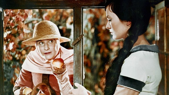 Die verkleidete böse Stiefmutter (Marianne Christine Schilling) bietet Schneewittchen (Doris Weikow) einen vergifteten Apfel an. 