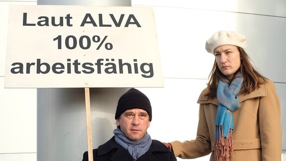 Harald Böhlert (Peter Schneider), Ines Böhlert (Marie Leuenberger) Das Ehepaar Böhlert demonstriert vor der Versicherungsfirma ALVA.