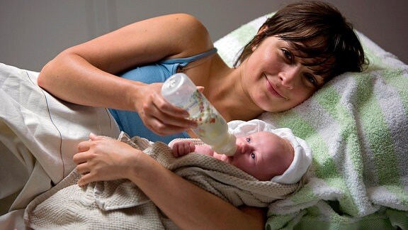 Dixie (Sarah Alles) hält glücklich ihr Baby im Arm.
