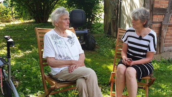 Leonore Pengel mit ihrer Tochter im Garten sitzend. 