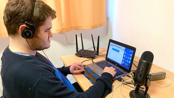 Ein junger Mann sitzt vor einem Laptop