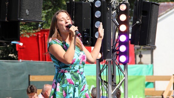 Eine Frau singt auf einer Bühne