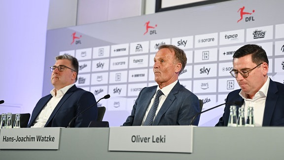 Axel Hellmann (l-r), Hans-Joachim Watzke und Oliver Leki, sprechen im Anschluss an die DFL-Mitgliederversammlung am Frankfurter Flughafen während einer Pressekonferenz.