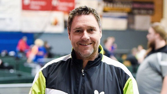Jochen Wollmert, fünfmaliger Paralympicssieger im Tischtennis, schaut lächelnd in die Kamera.