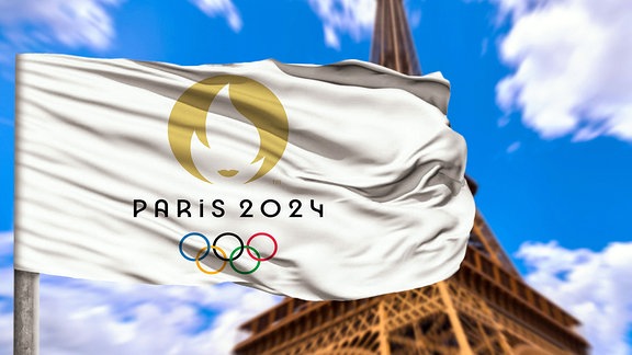 Fotomontage - Die Flagge der Olympischen Spiele 2024 in Paris weht vor dem Eiffelturm in Frankreich.