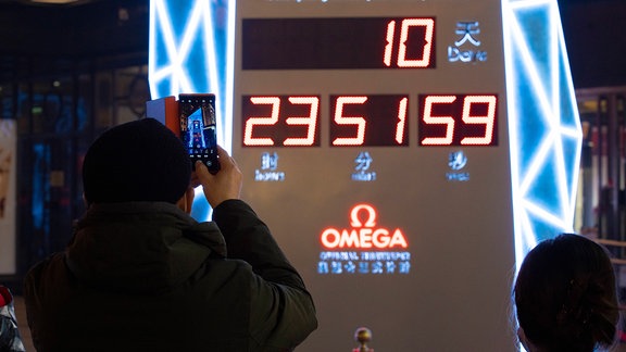 Person fotografiert Countdown-Uhr 10 Tage vor Eröffnung der Olympischen Winterspiele in Peking.